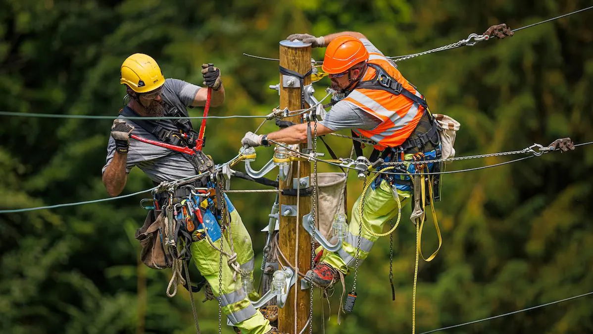 Deux électriciens travaillant sur un pylône de moyenne tension