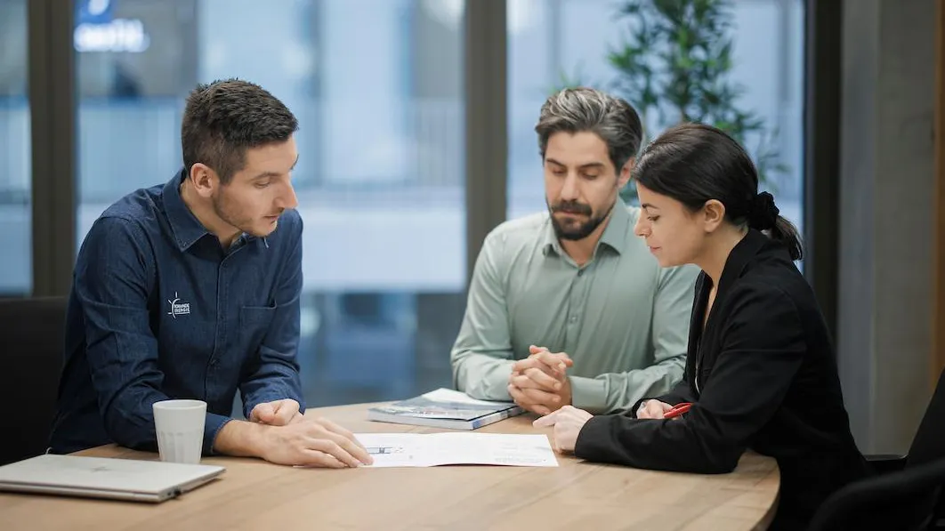 Collaborateur Romande Energie face à deux clients