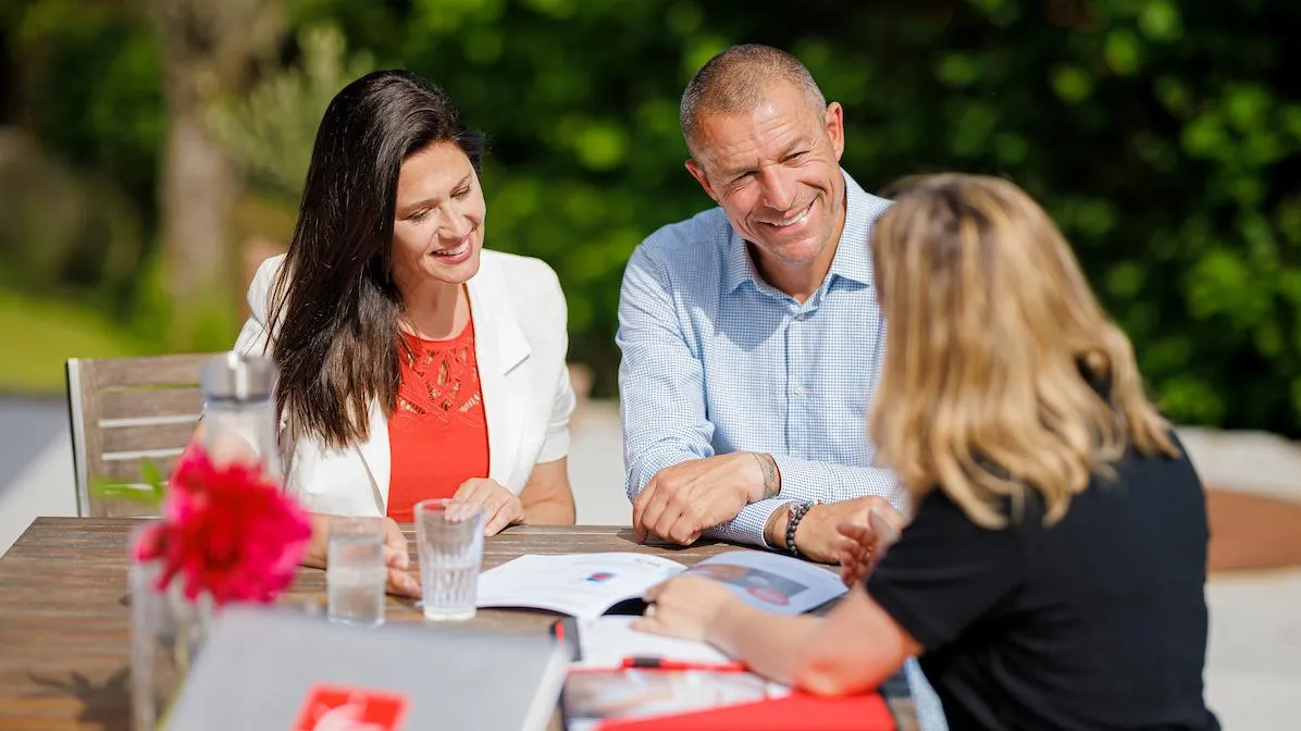 Conseillère Romande Energie avec un couple clients