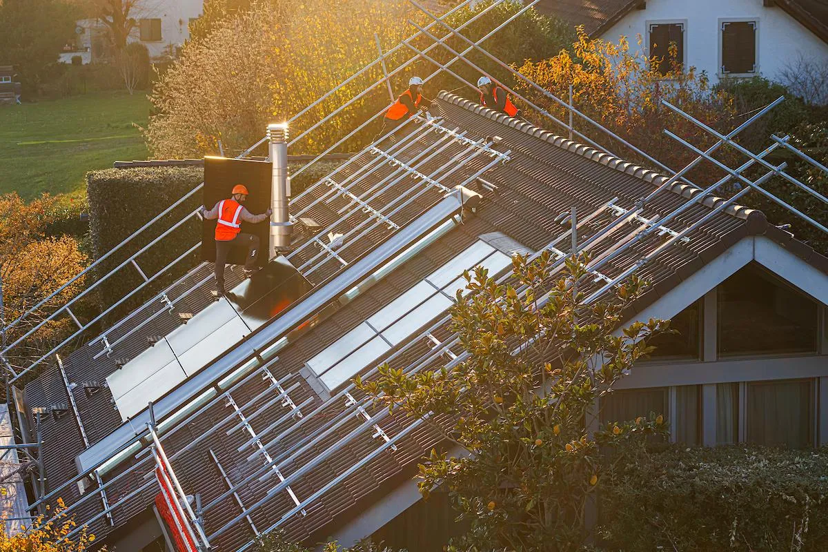 Installateurs solaires sur un toit de maison individuelle