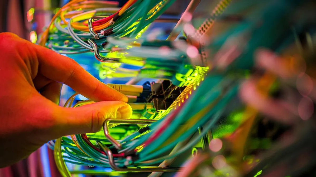 Main touchant des câbles dans un data center