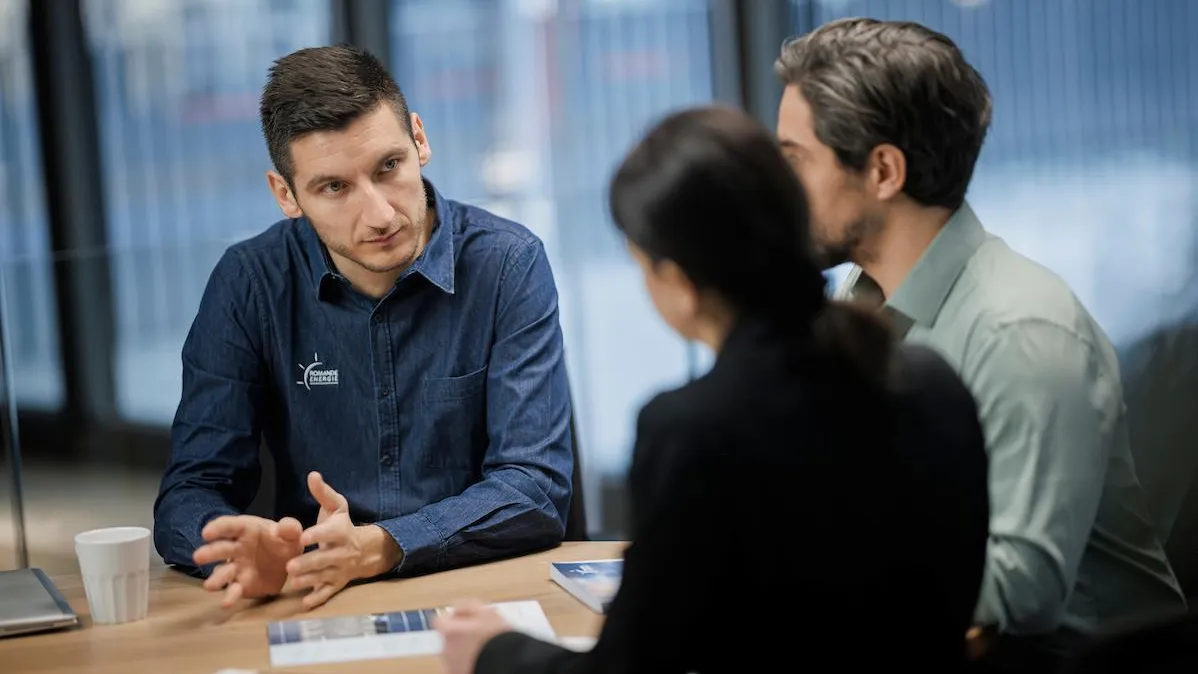 Commercial Romande Energie échangeant avec des clients