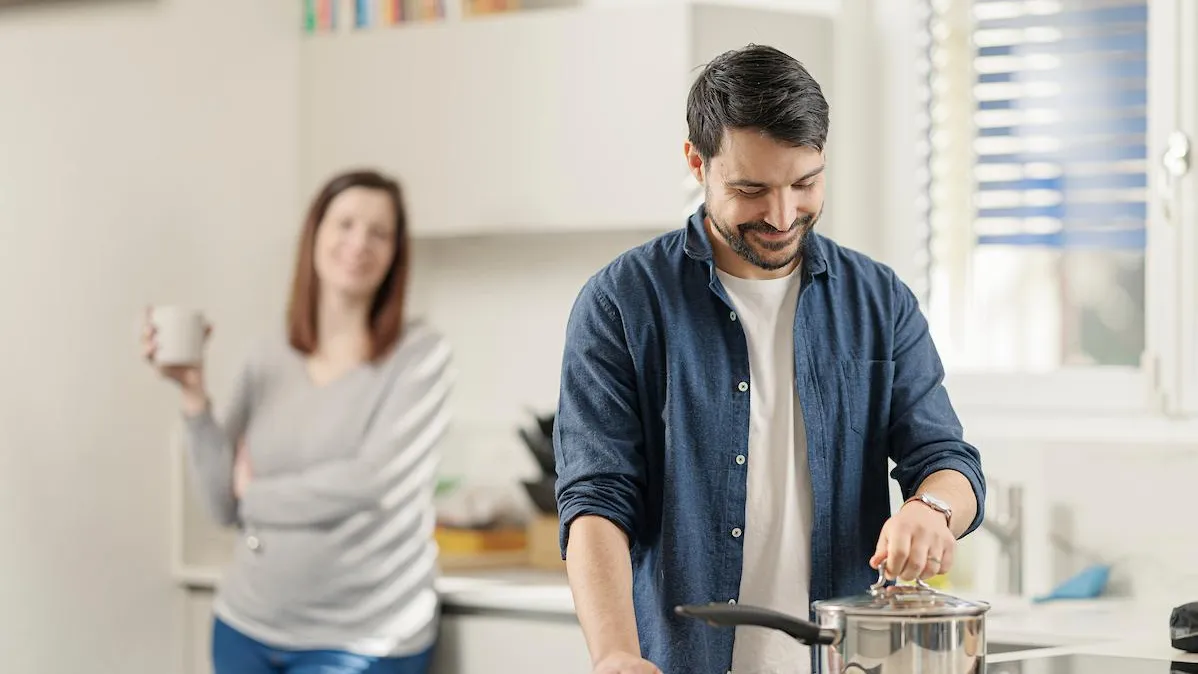 Couple clients Romande Energie cuisinant avec le couvercle sur la casserole