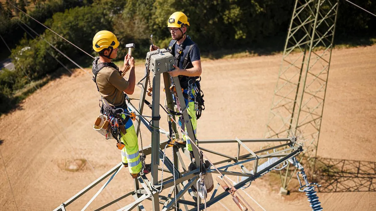 Collaborateurs Romande Energie travaillant sur une ligne à haute tension