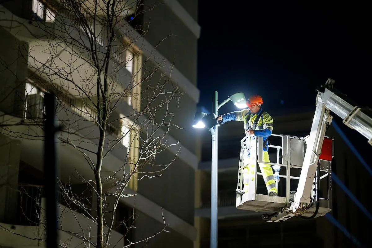 Collaborateur RE posant un éclairage dans un quartier