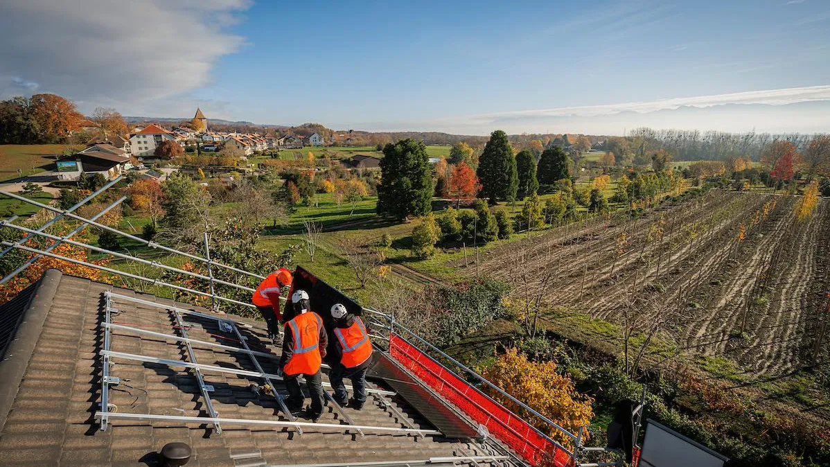 Installateurs solaires sur un toit de maison individuelle de campagne