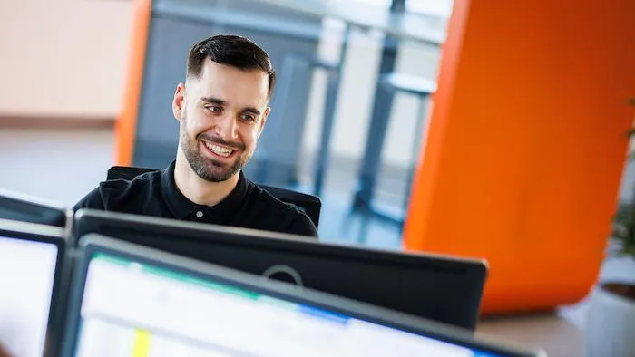 Collaborateur Romande Energie souriant à son bureau