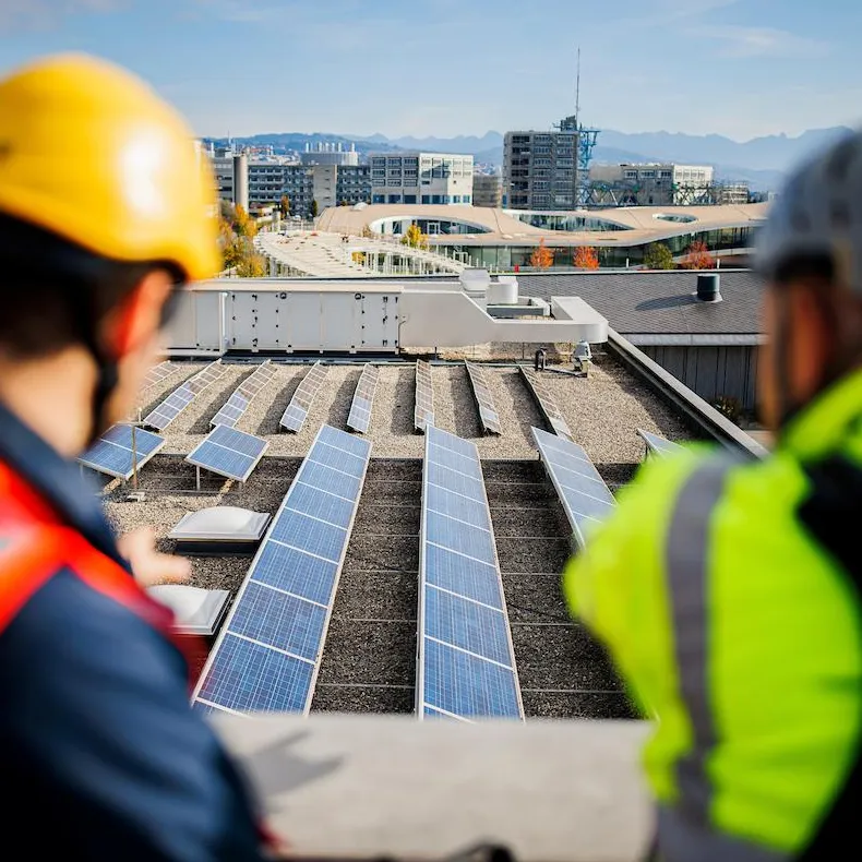 Deux collaborateurs Romande Energie regardant le parc solaire de l'EPFL