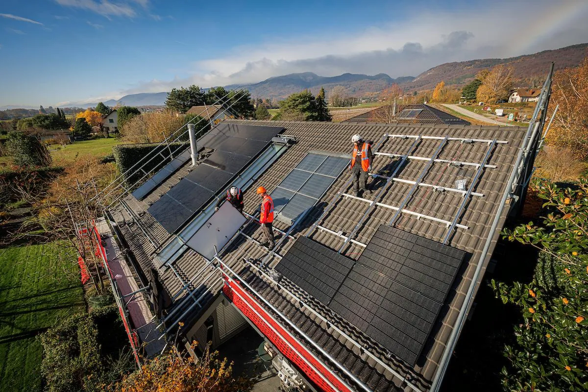 Installateurs entrain de poser des panneaux solaires sur une maison individuelle 